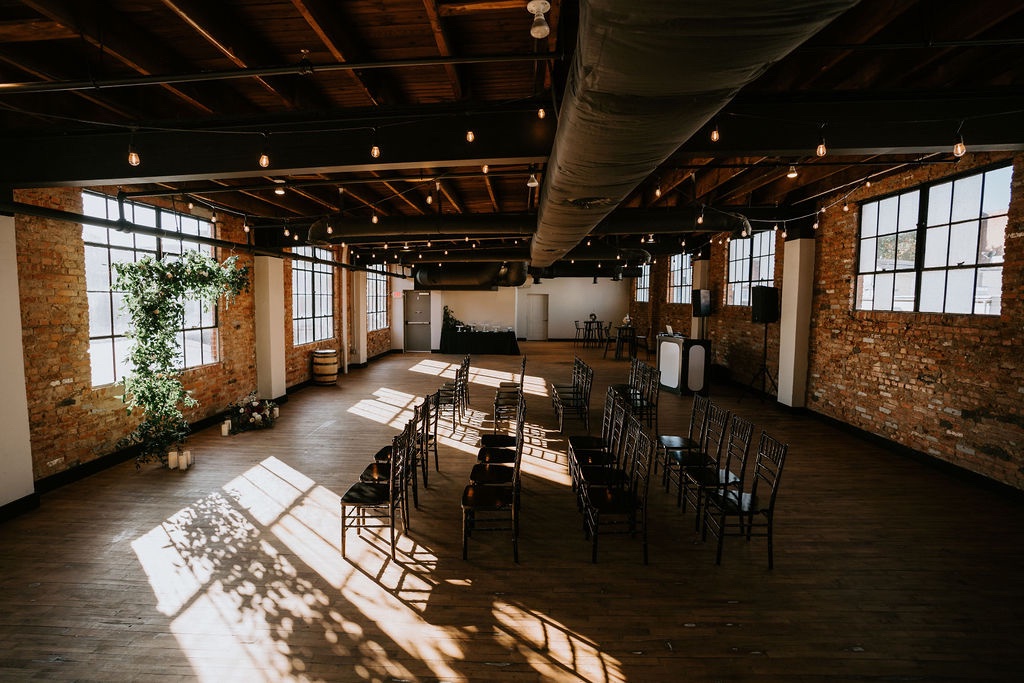 Beautiful wedding ceremony setup with flowers and black chivari chairs at Tenth Ward